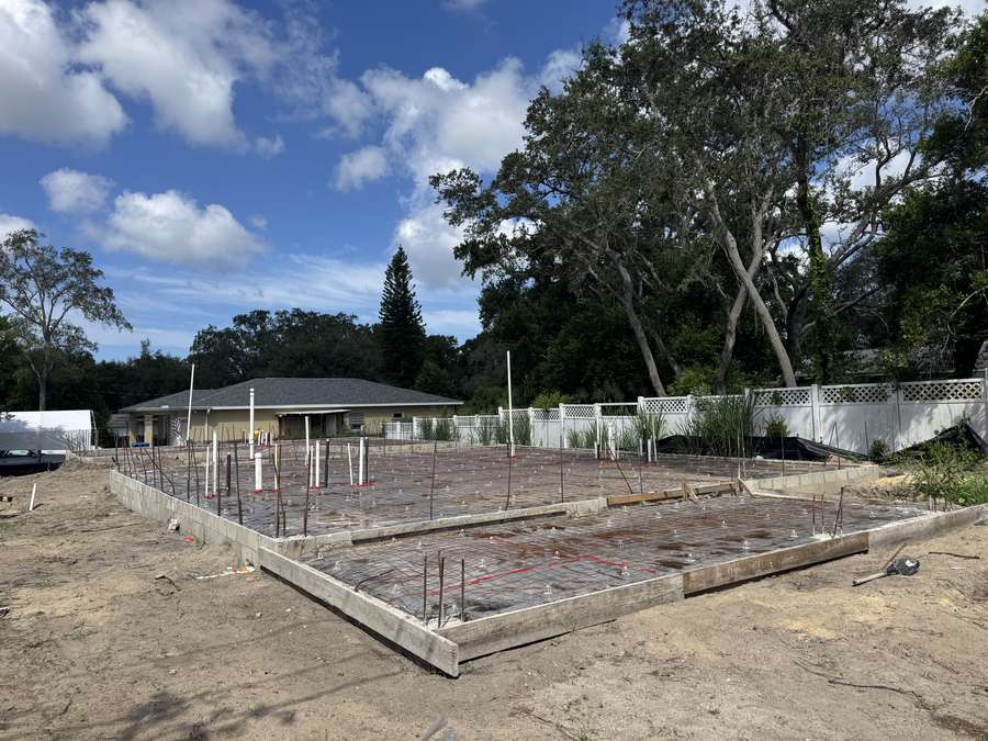 Rebar grid, concrete forms, and plumbing stub-outs prepared for a custom home slab pour
